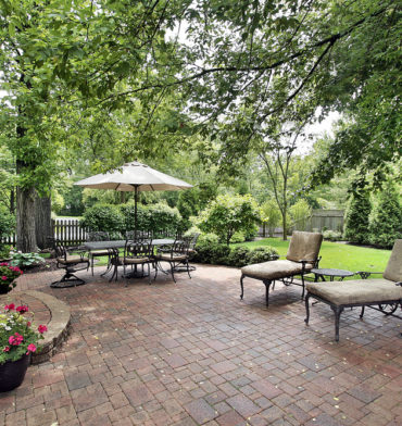 Brick patio with table umbrella and chairs - Big Easy Patio